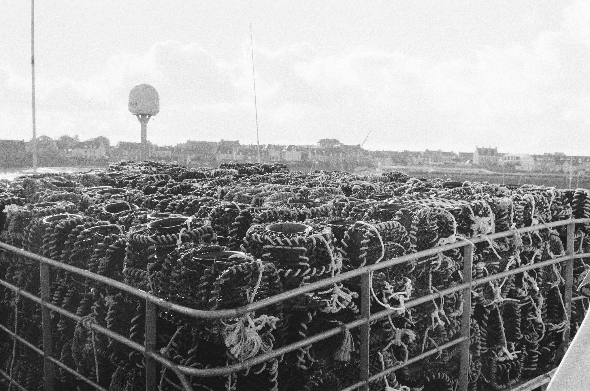 2025/022: Käfige zum Fischen auf einem Fischerboot in Roscoff, Bretagne. Im Hintergrund sieht man den Kai der Altstadt.