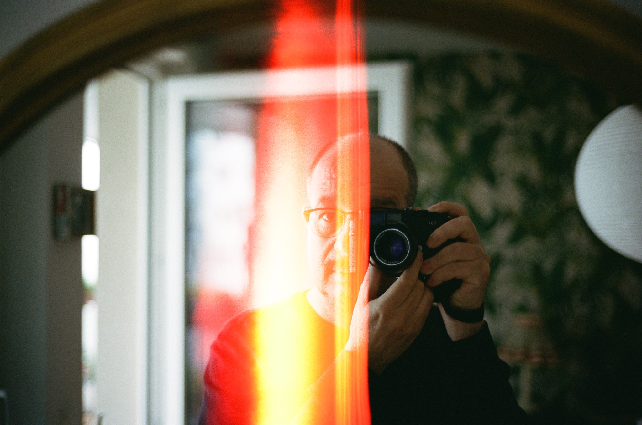 Selfie vor dem Wohnzimmerspiegel mit Lightleak in der Mitte des Frames.