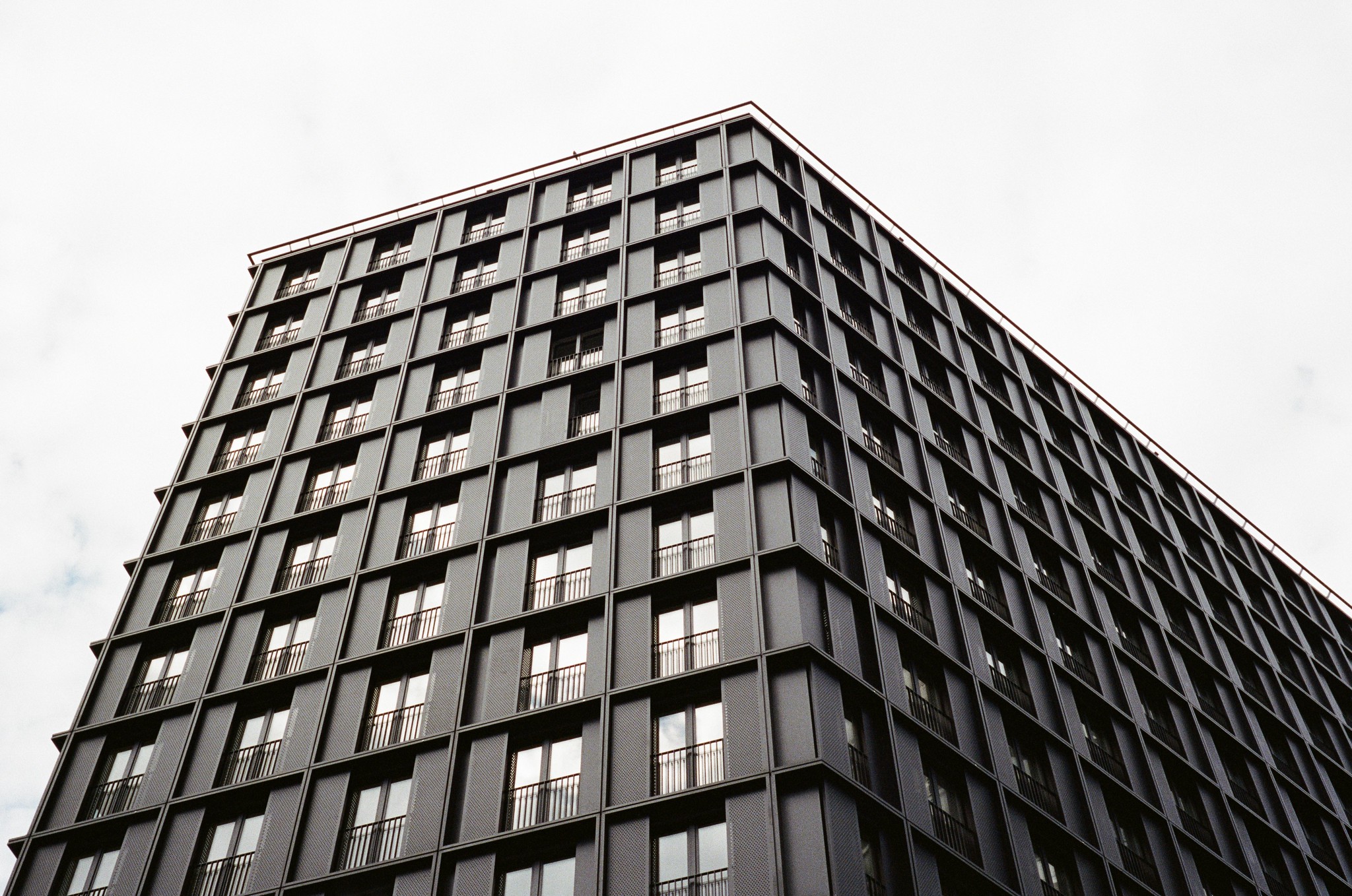 Hochhausfassade in Schwarz mit Sichtschutzblenden. Ein Neubau in Kaisermühlen, Donaustadt, Wien.